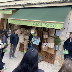 IES Manacor amb el Comerç Verd. Fotografia d'un grup de persones davant un establiment.